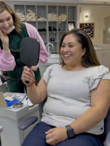 Happy patient seeing her smile transformation for the first time after braces removal at Giardina Orthodontics in Harrisonburg, VA